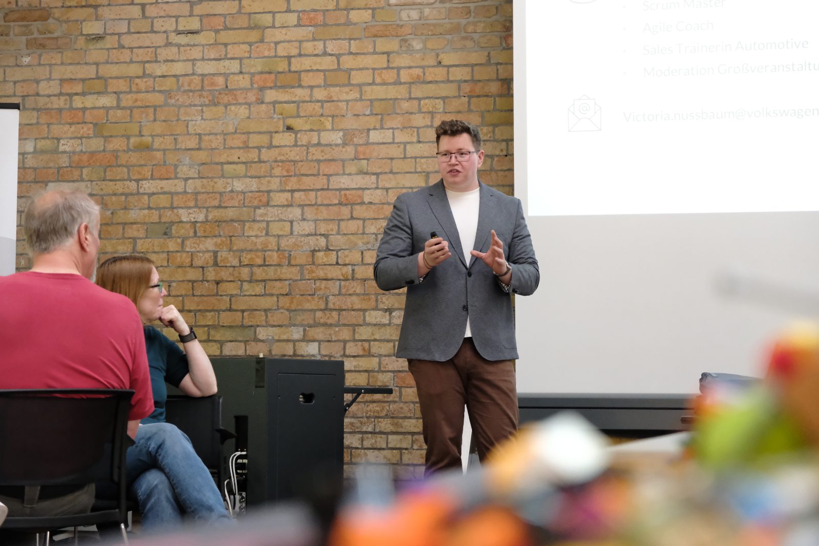 Stefan Kuper moderiert einen Team-Workshop vor einer Backsteinwand